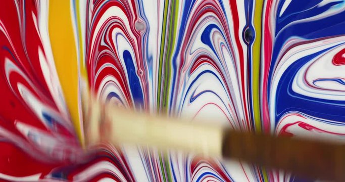 Colorful poster paint abstract painting with yellow being brushed red white and blue.