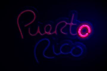 3D Rendering of a wet neon Puerto Rico sign with one letter glowing.