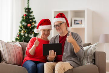 happy senior couple with tablet pc at christmas