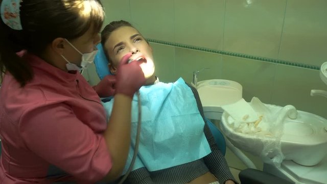 charming girl at the dentist treats her teeth