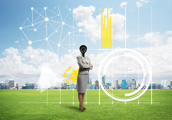 Camera headed woman standing on green grass against modern cityscape
