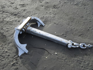 Anchor, shells and footsteps in the sand of Terschelling beach, Netherlands.
