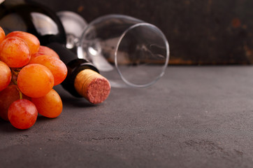 ripe grapes, red wine and a glass on a black background