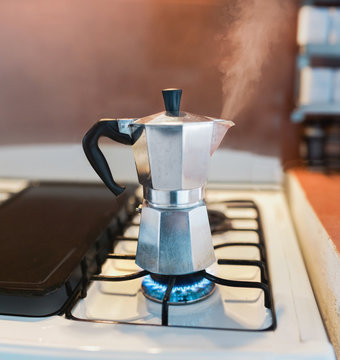 Steaming Italian coffee percolator on gas stove