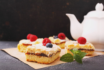 Homemade pie with berries cut into pieces on the black background