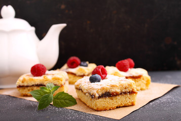 Homemade pie with berries cut into pieces on the black background