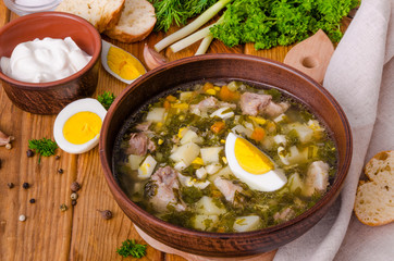 Soup with fresh herbs, vegetables and eggs. A traditional Russian and Ukrainian dish.