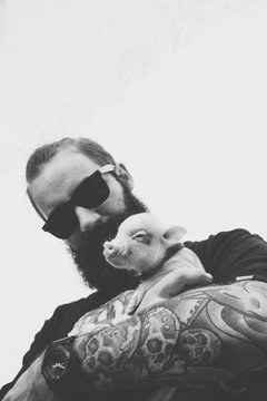 brutal man with piglet in hand