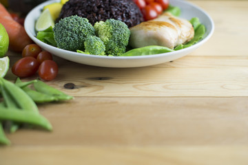 Clean food top view on woo table on disk have vegetable and chicken