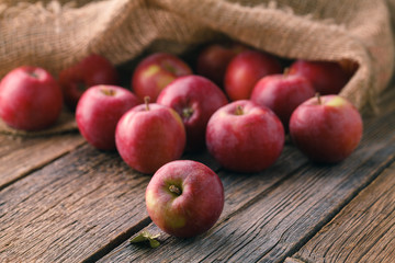 Heap of red apples in bulrap bag