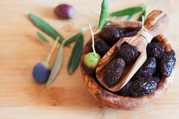 Served dried black olives in wooden olive bowl