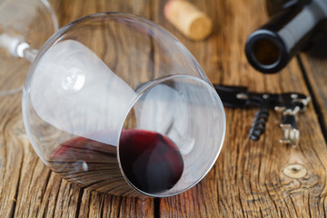 Wine glass with drop of red wine lay on table - obrazy, fototapety, plakaty