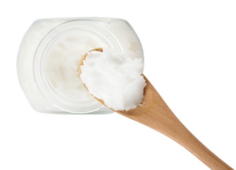 Spoon with coconut oil and jar on white background