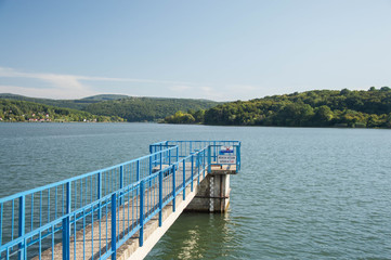 Lake with a pier and blue railing