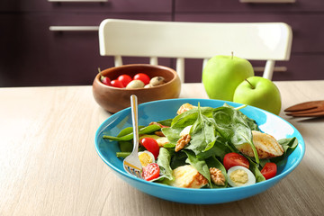 Plate of tasty salad with spinach leaves  on wooden table