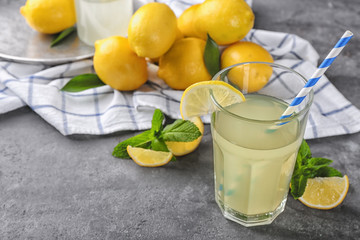 Glass of fresh lemon juice on table