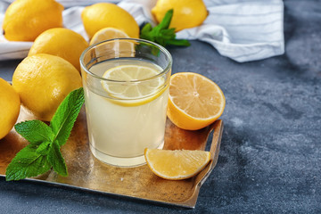 Glass of fresh lemon juice on metal tray