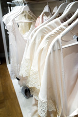Fototapeta na wymiar White nightgowns hang in store