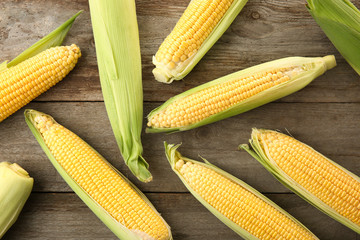 Fresh corn cobs on wooden table