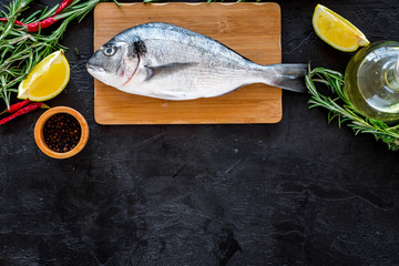 Preparing fresh sea fish. Black background top view copyspace