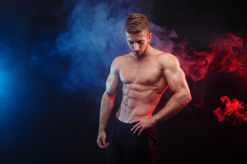 Young fit man bodybuilder with perfect big muscles. Muscled male model posing