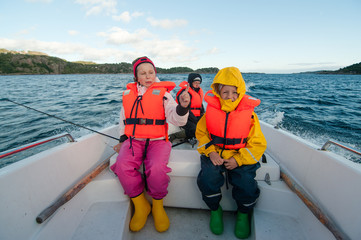 Father with kids riding motor boat in the sea