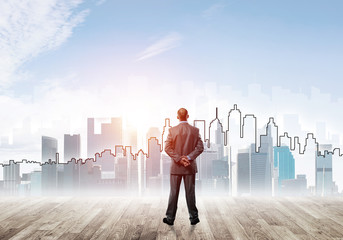 Motivation and inspiration concept with modern cityscape and businessman observing it