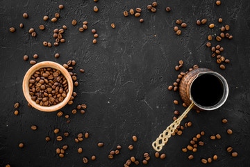 Brew coffee in turkish coffee pot. Black background top view copyspace