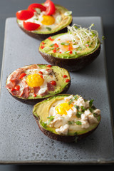 eggs baked in avocado with bacon, cheese, tomato and alfalfa sprouts
