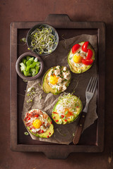 eggs baked in avocado with bacon, cheese, tomato and alfalfa sprouts