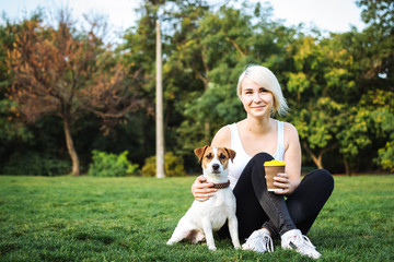 Young woman with cute jack russel terrier in park