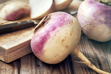 Closeup of raw organic turnips on rustic wooden background - obrazy, fototapety, plakaty