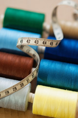 Pile of colorful spools of thread and measuring meter