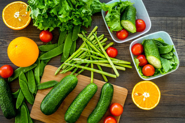 Healthy meal in containers. Salad with tomato and cucumber in cotainers on wooden background top view