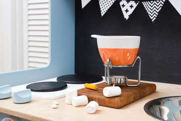 Party dessert. Swiss chocolate fondue with marshmellows on black background