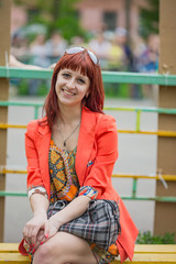 Red-haired girl sitting in the Park