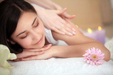 Obraz na płótnie Canvas people, beauty, spa, healthy lifestyle and relaxation concept - close up of beautiful young woman lying with closed eyes and having face or head massage in spa
