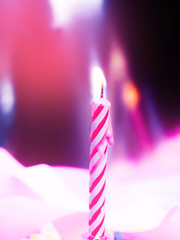 one single candle on a birthday, holiday, blow out candle, the smoke from the candles. Pink tone, copy space