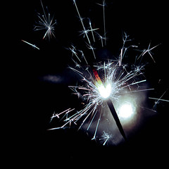 Festive background, bengal light on the dark background, New Year with sparklers sparks on a black background