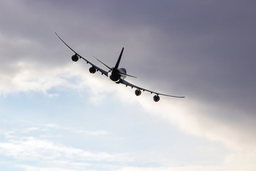 Airplane flying in the cloudy sky. Turn right.