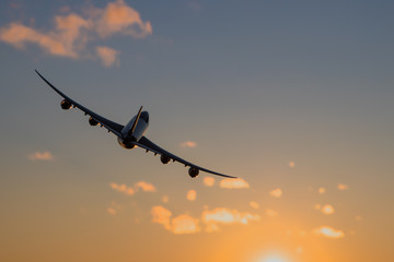 Airplane flying over city with skyscrapers at night. Turn right. Purple sunset.