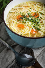 Broth - chicken soup in a blue bowl.