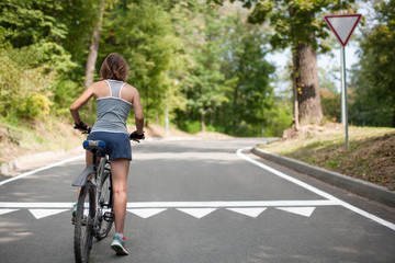 Young Woman riding bicycle. Observance of traffic law