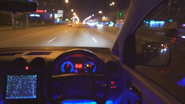 The autopilot drive a car in the city. night time, inside view, left side traffic