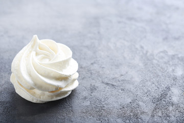 Tasty meringue cookies on grey wooden table