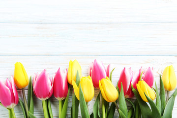 Bouquet of bright tulips on white wooden table