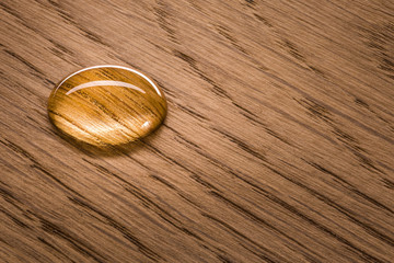 Three water beads on finished oak wood