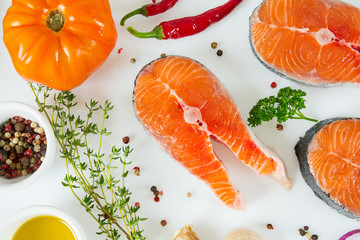 pieces of salmon and herbs over white