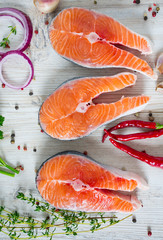 freshly cut raw salmon with spices on wooden surface