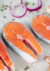 freshly cut raw salmon with spices on wooden surface